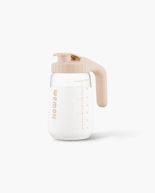 WEMOH P1 Original breast milk pitcher in warm beige, with 32oz glass body, measuring marks, handle, and leakproof lid.