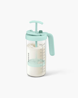 WEMOH P1 Plus glass formula mixing pitcher in mint green with 32oz glass body, mixing handle, time dial, and measuring marks.